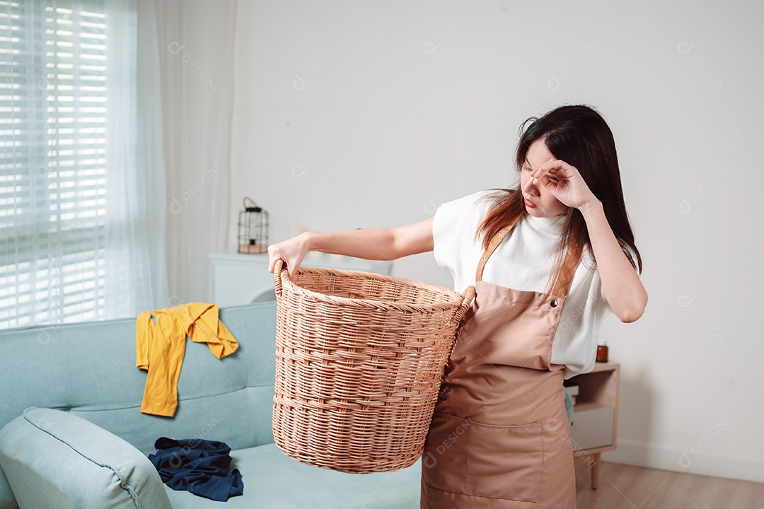 Mulher asiática limpando tarefas domésticas na sala de estar em casa.