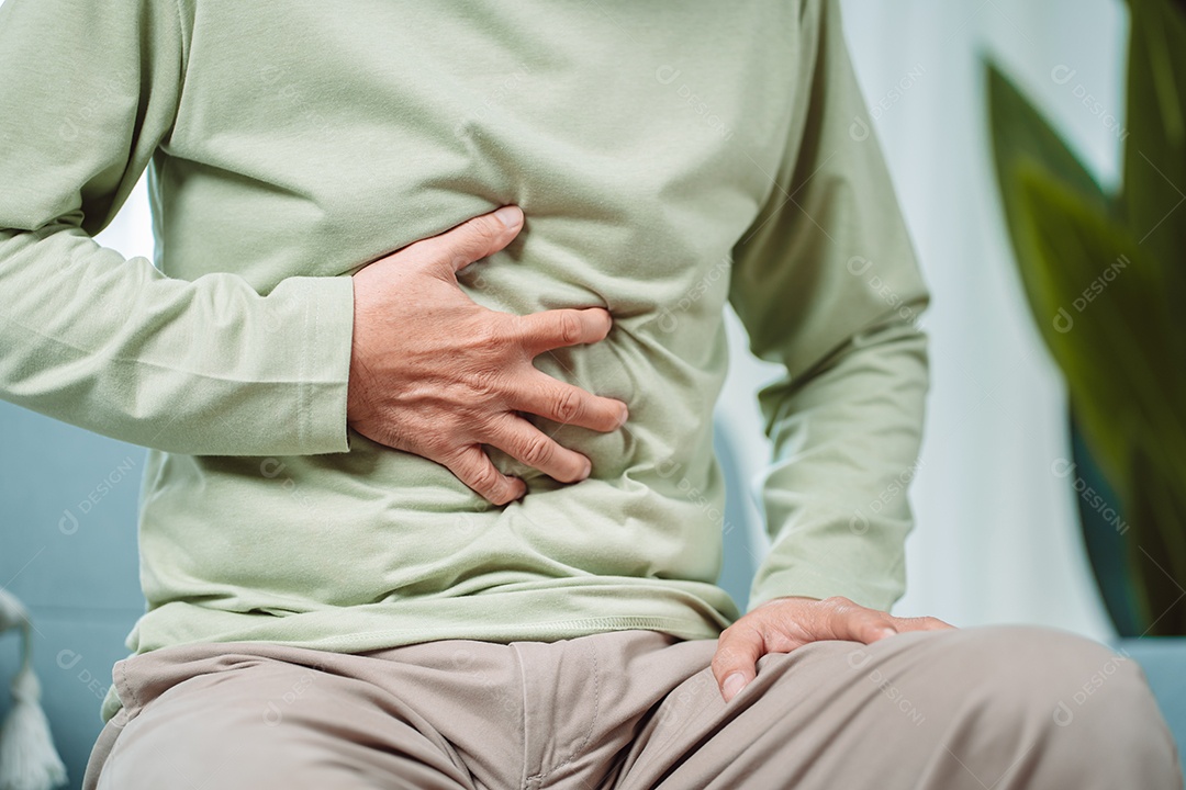 Homem sênior asiático sente dor de estômago.