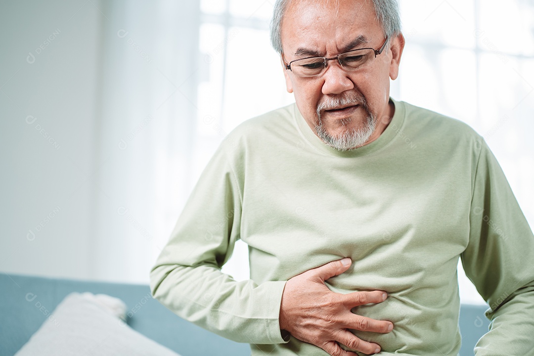 Homem sênior asiático sente dor de estômago.