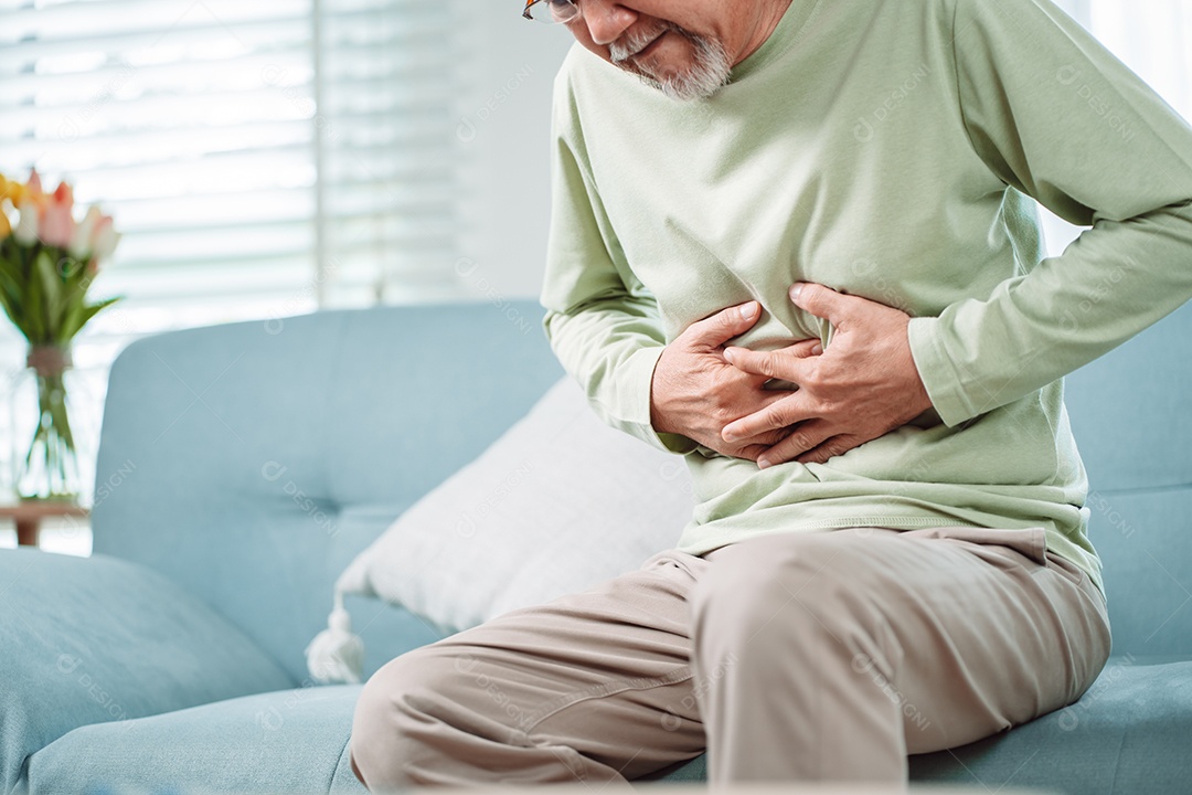 Homem sênior asiático sente dor de estômago.