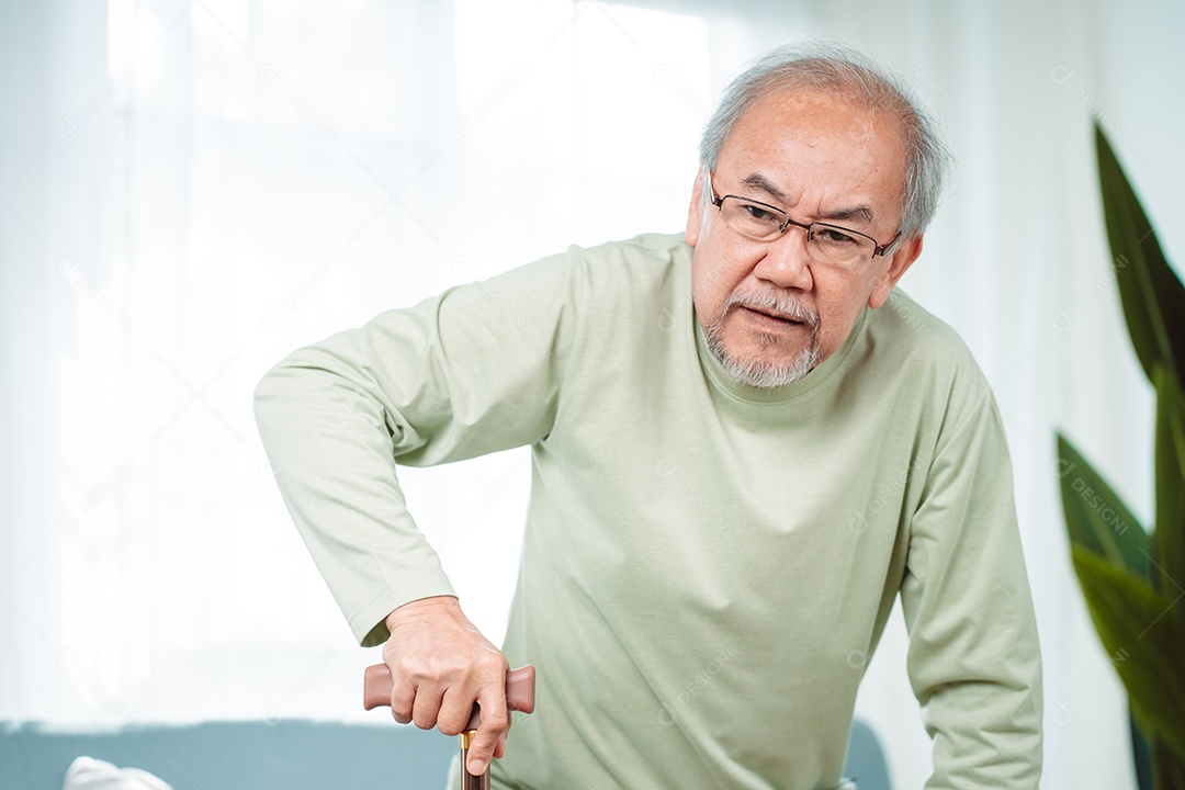 Sorrindo feliz do velho idoso asiático sentado no sofá com andador ou bengala em casa