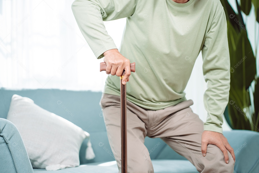 Sorrindo feliz do velho idoso asiático sentado no sofá com andador ou bengala em casa
