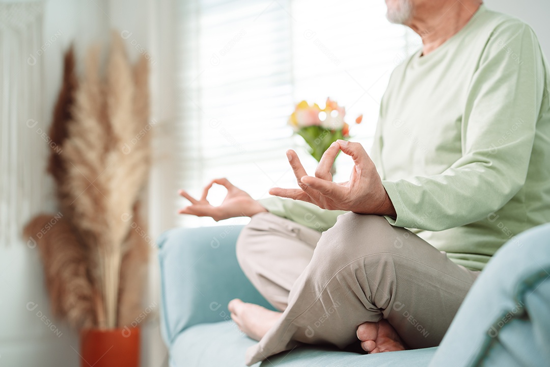 Idoso asiático fazendo ioga relaxa na sala de estar em casa