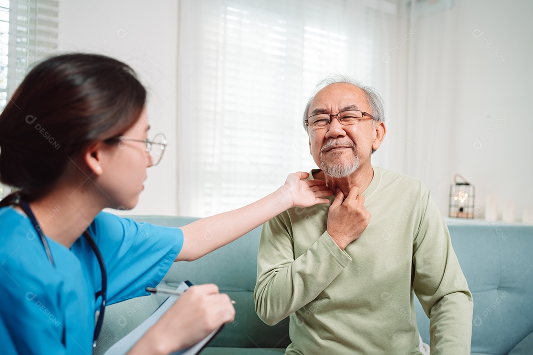 Cuidador asiático falando sobre check-up de paciente masculino sênior na sala de estar em casa.