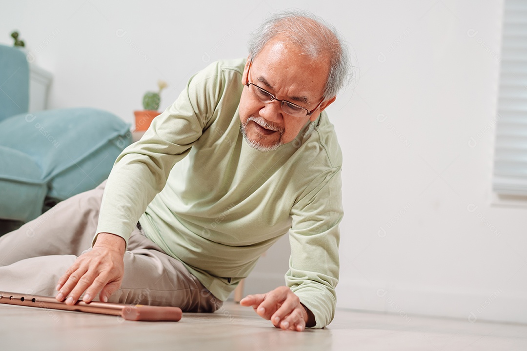 Homem sênior asiático caindo no chão com bengala na sala de estar em casa.