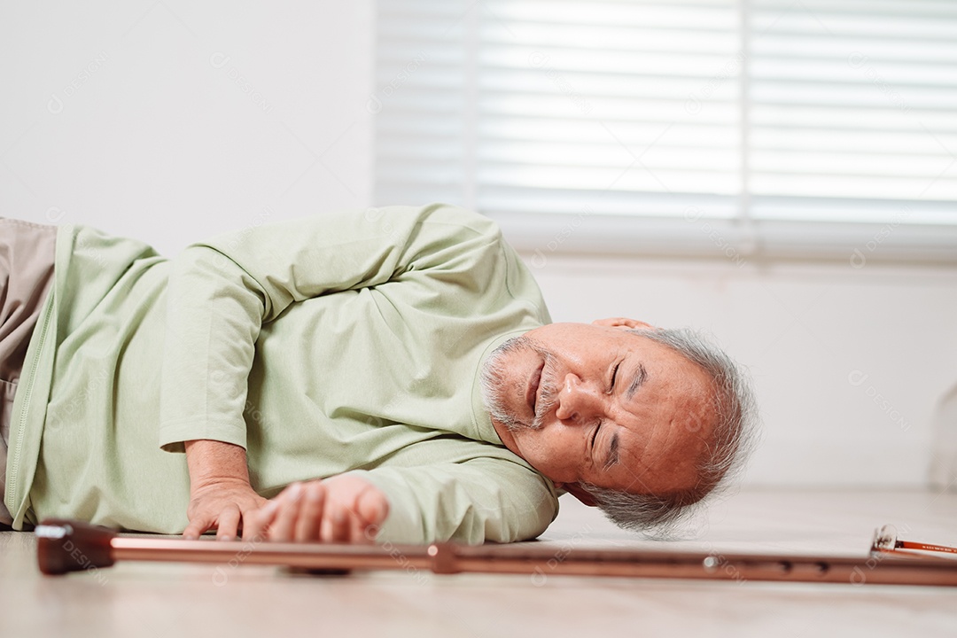 Homem sênior asiático caindo no chão com bengala na sala de estar em casa.