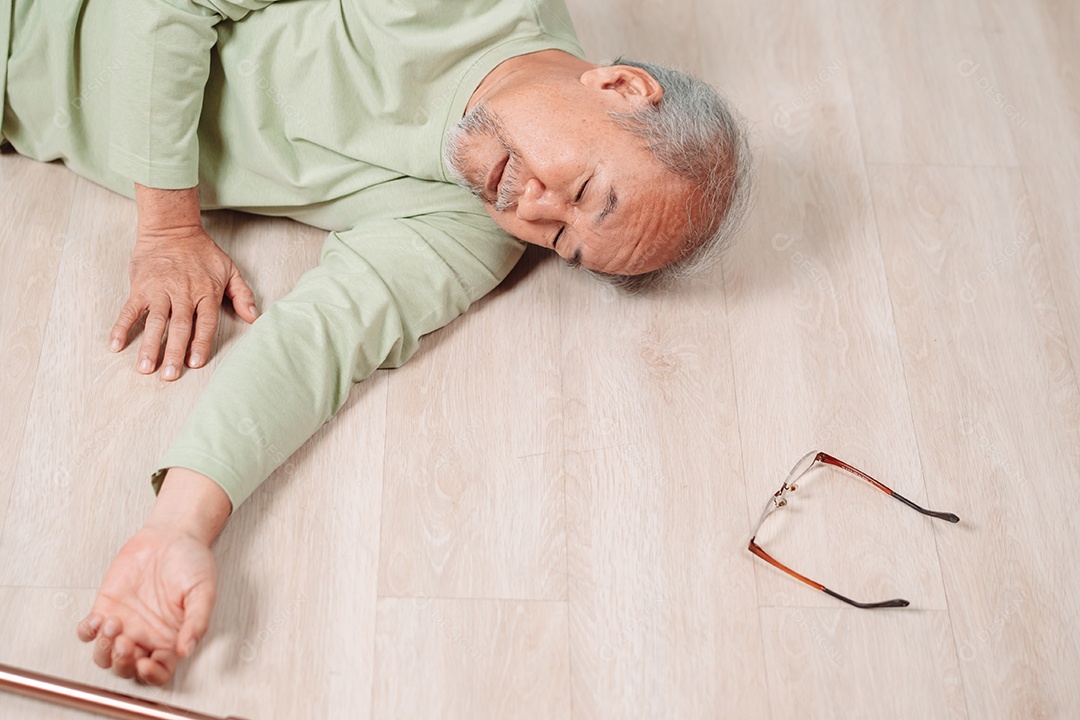 Homem sênior asiático caindo no chão com bengala na sala de estar em casa.