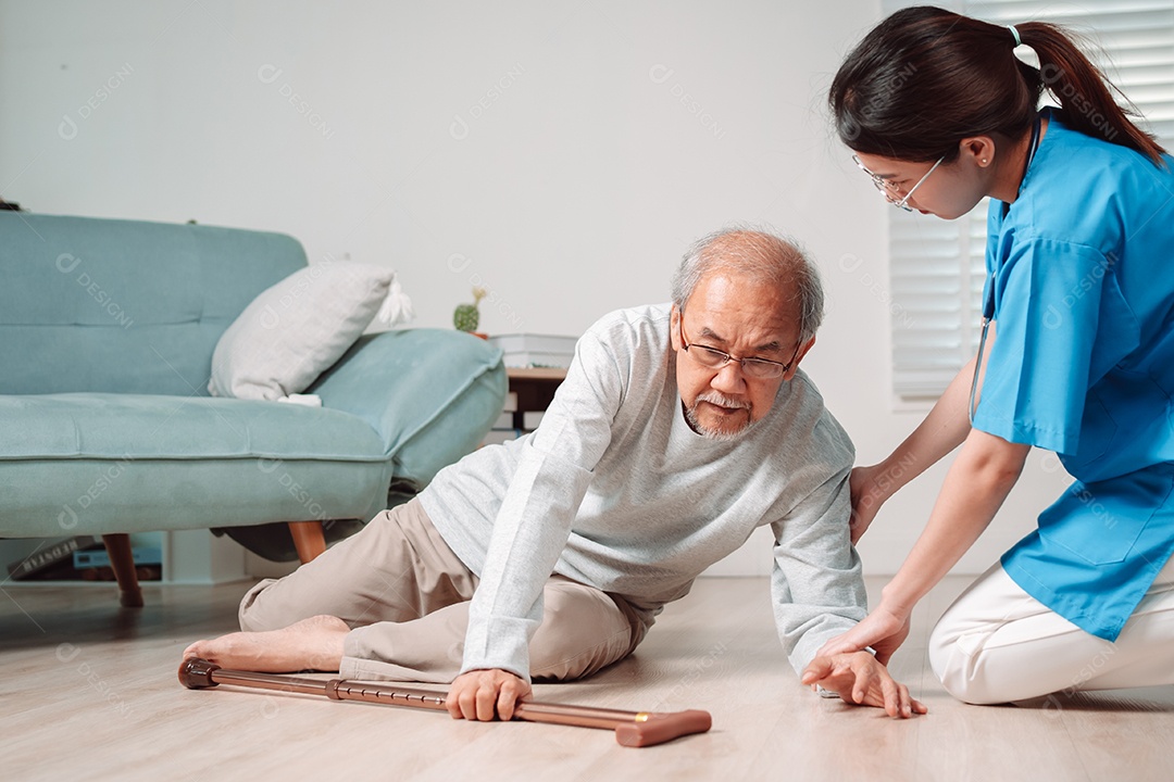 Mulher asiática ajudando o homem sênior que caiu no chão na sala de estar em casa.
