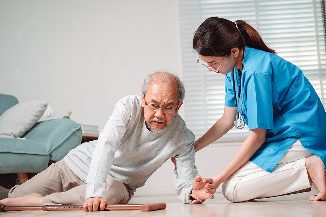 Mulher asiática ajudando o homem sênior que caiu no chão na sala de estar em casa.