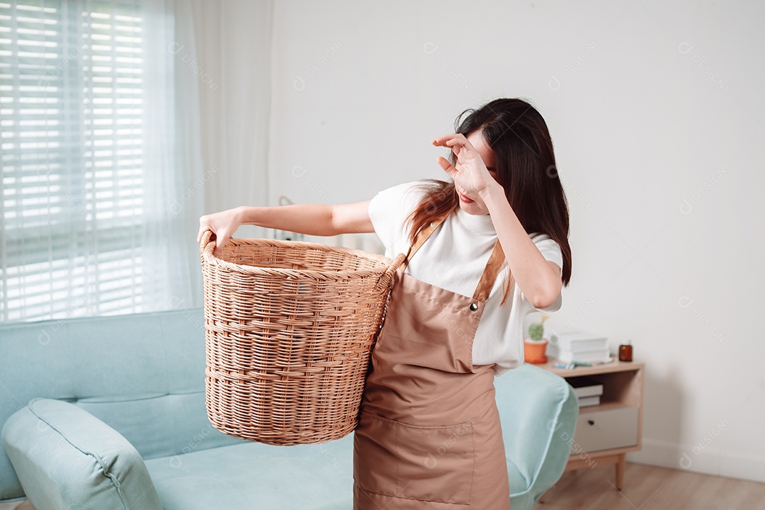 Mulher asiática fazendo tarefas domésticas leva roupas sujas no cesto