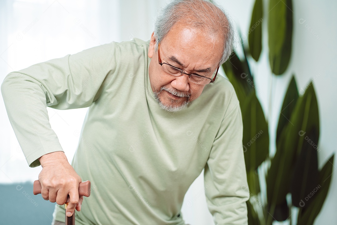 Idoso asiático com deficiência paciente caminhando lentamente seu andador de uso ou bengala na sala de estar em casa.