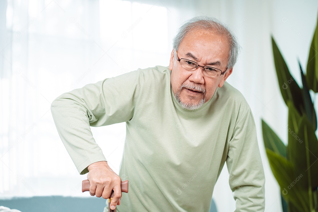 Idoso asiático com deficiência paciente caminhando lentamente seu andador de uso ou bengala na sala de estar em casa.