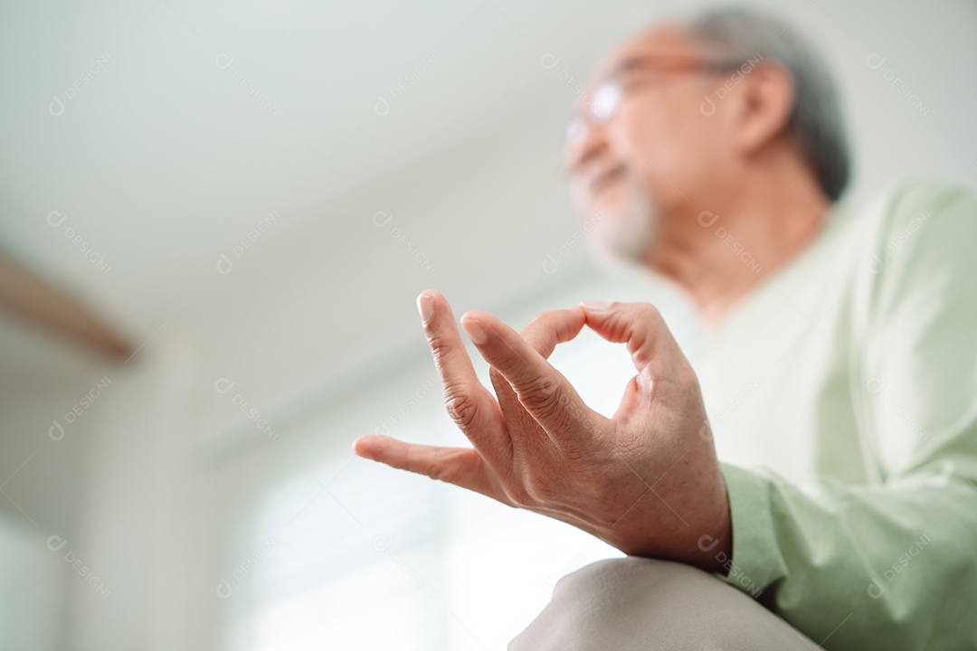 Idoso asiático fazendo ioga relaxa na sala de estar em casa