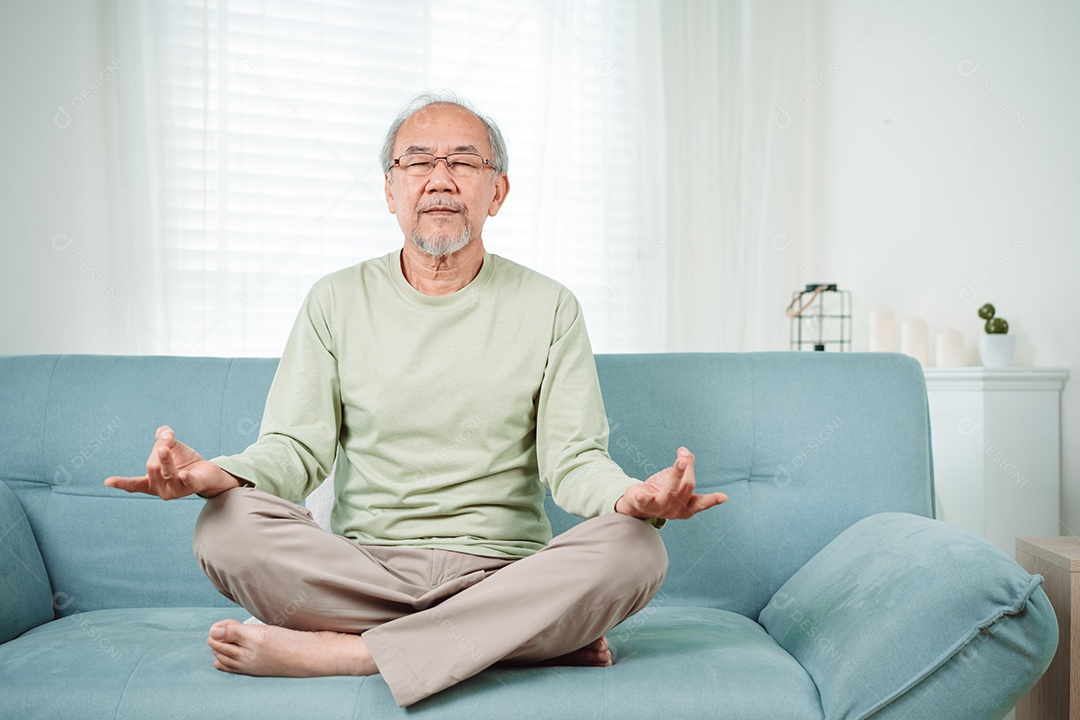 Idoso asiático fazendo ioga relaxa na sala de estar em casa