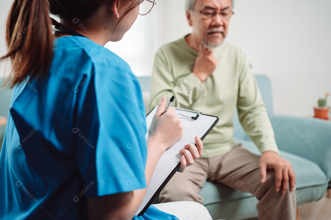 Cuidador asiático falando sobre check-up de paciente masculino sênior na sala de estar em casa.
