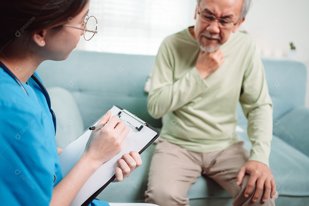 Cuidador asiático falando sobre check-up de paciente masculino sênior na sala de estar em casa.