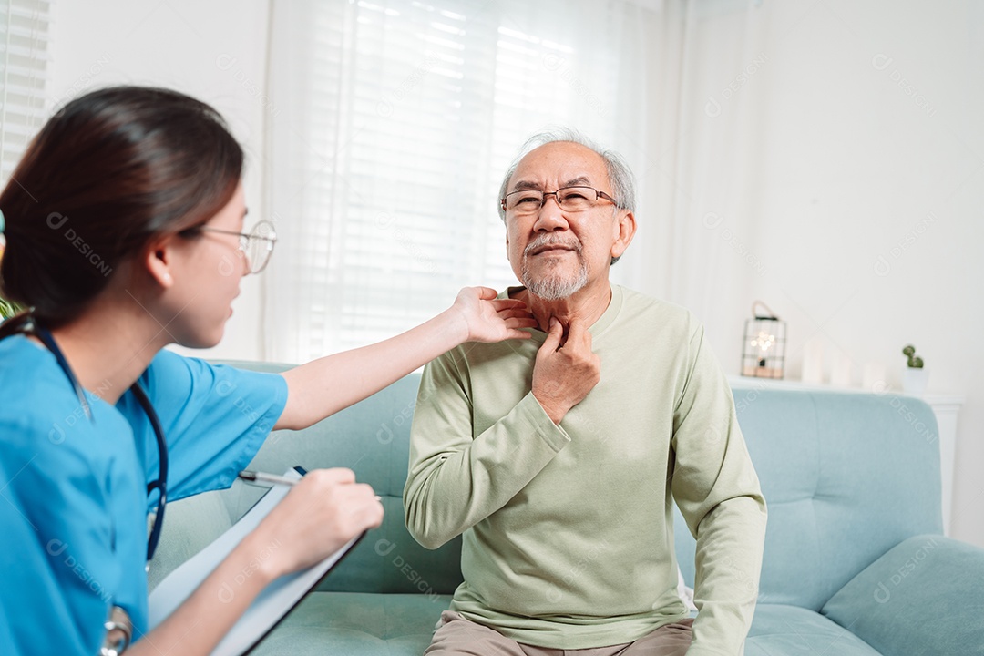 Cuidador asiático falando sobre check-up de paciente masculino sênior na sala de estar em casa.
