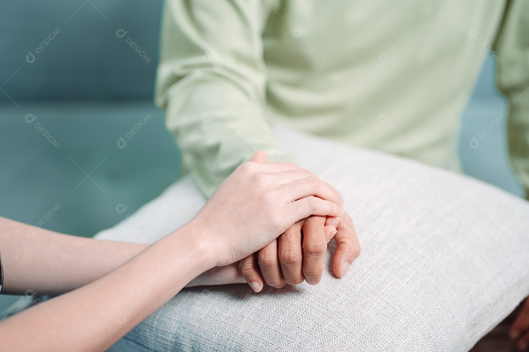 Cuidador asiático de mãos dadas com idoso