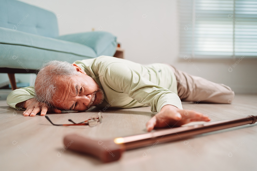 Homem sênior asiático caindo no chão com bengala na sala de estar em casa.
