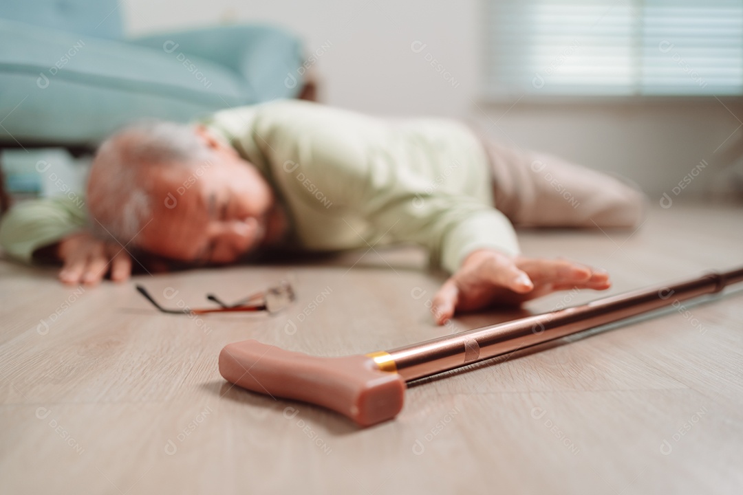 Homem sênior asiático caindo no chão com bengala na sala de estar em casa.