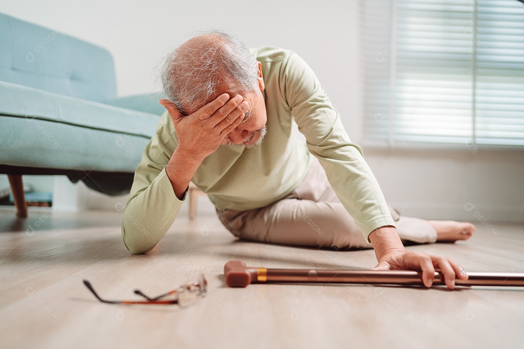 Homem sênior asiático caindo no chão com bengala na sala de estar em casa.