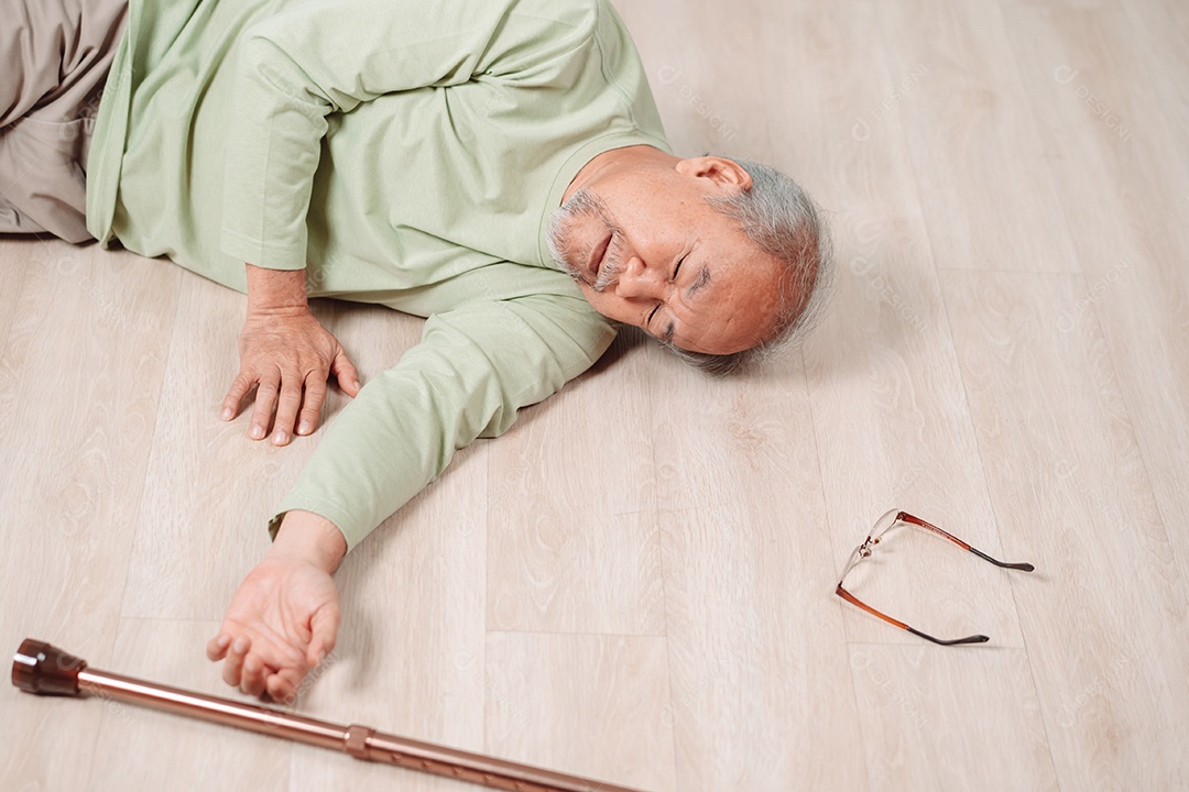 Homem sênior asiático caindo no chão com bengala na sala de estar em casa.