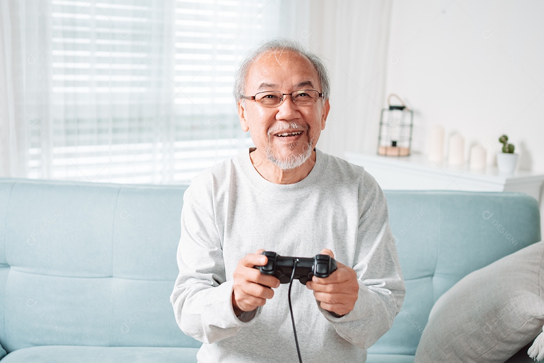 Homem sênior asiático se divertindo jogando vídeo em casa