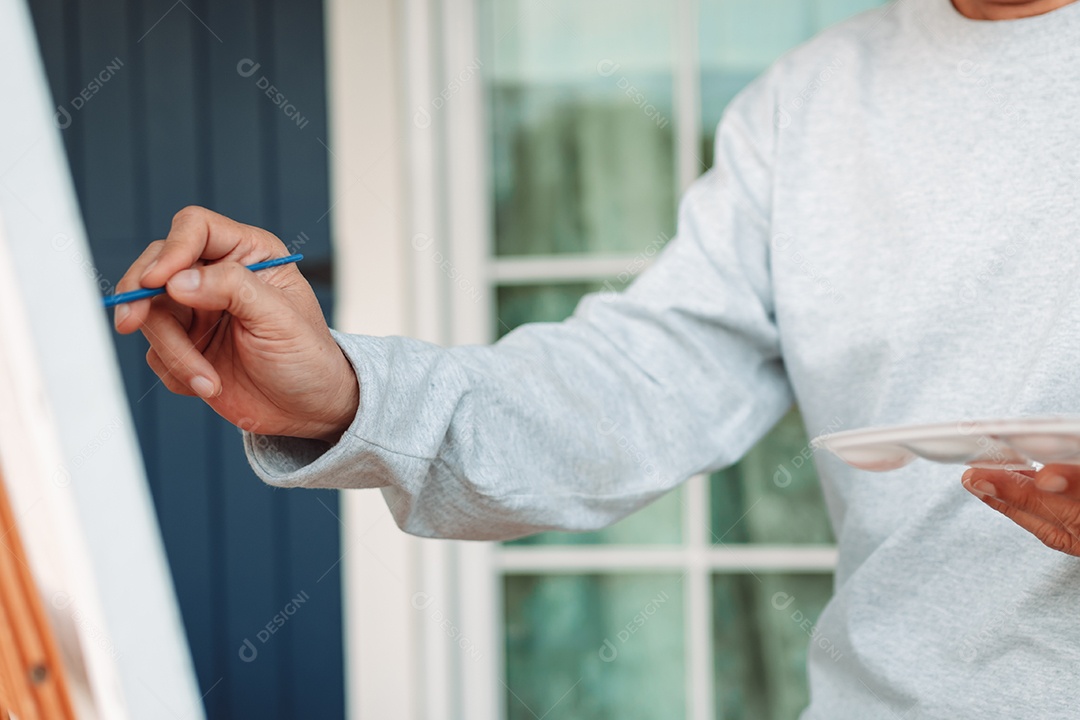 Homem idoso feliz pintando tela