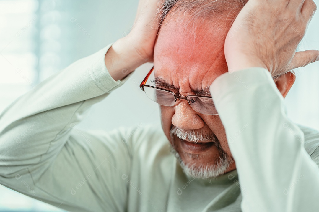 Idoso asiático sentindo dor de cabeça, sofrimento e enxaqueca na sala de estar em casa.