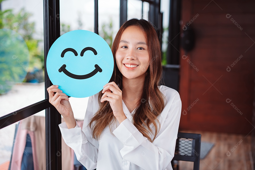 Mulher asiática segurando sorriso feliz azul no corte de papel