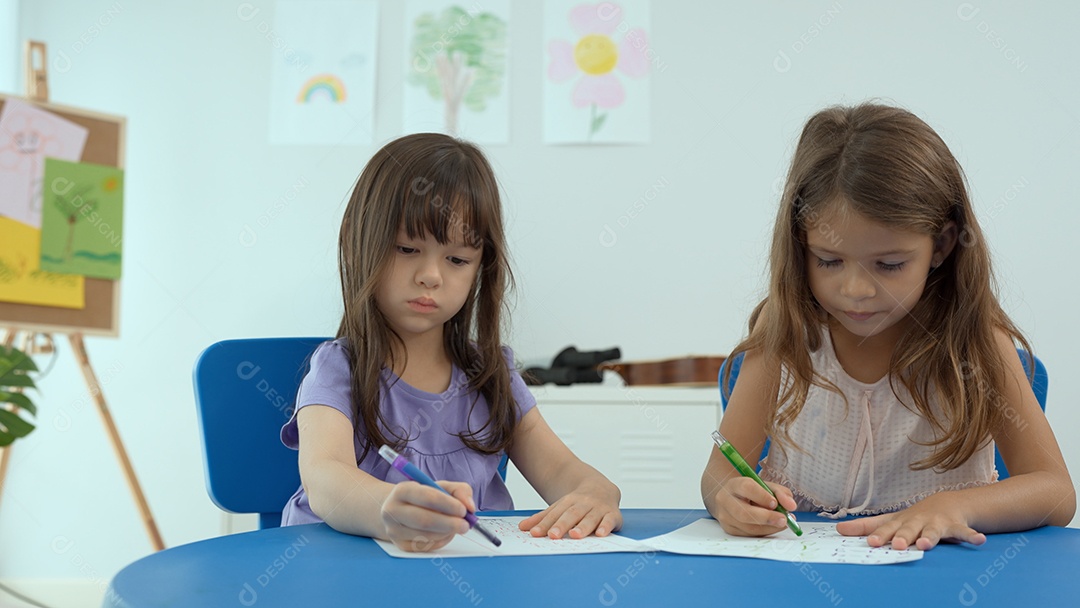 Duas meninas alunas colorindo na escola