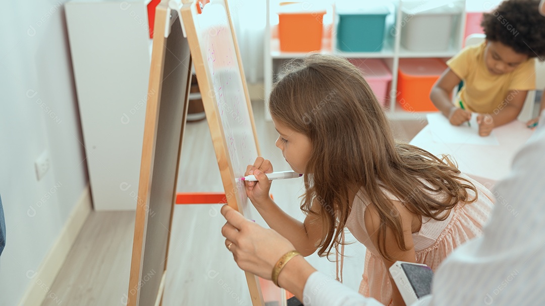 Menina desenhando no quadro da escola