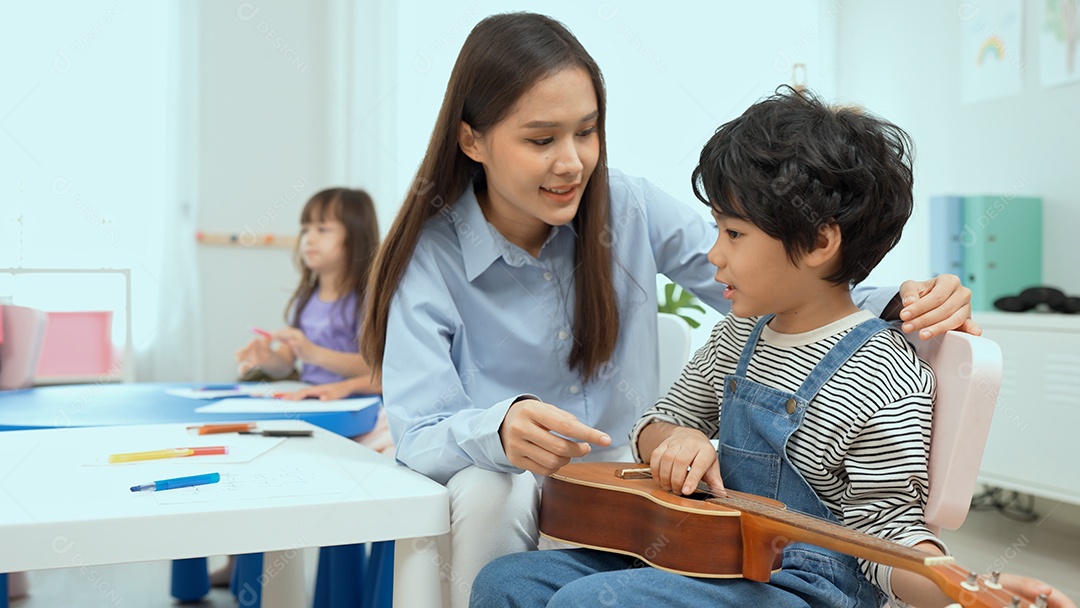 Jovem professor asiático ensinando violão e ukulele para seu garotinho.