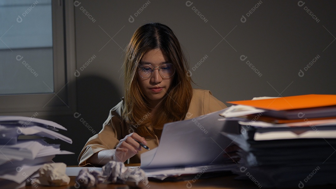 Empresária asiática ou freelancer trabalhando duro à noite olhando o computador