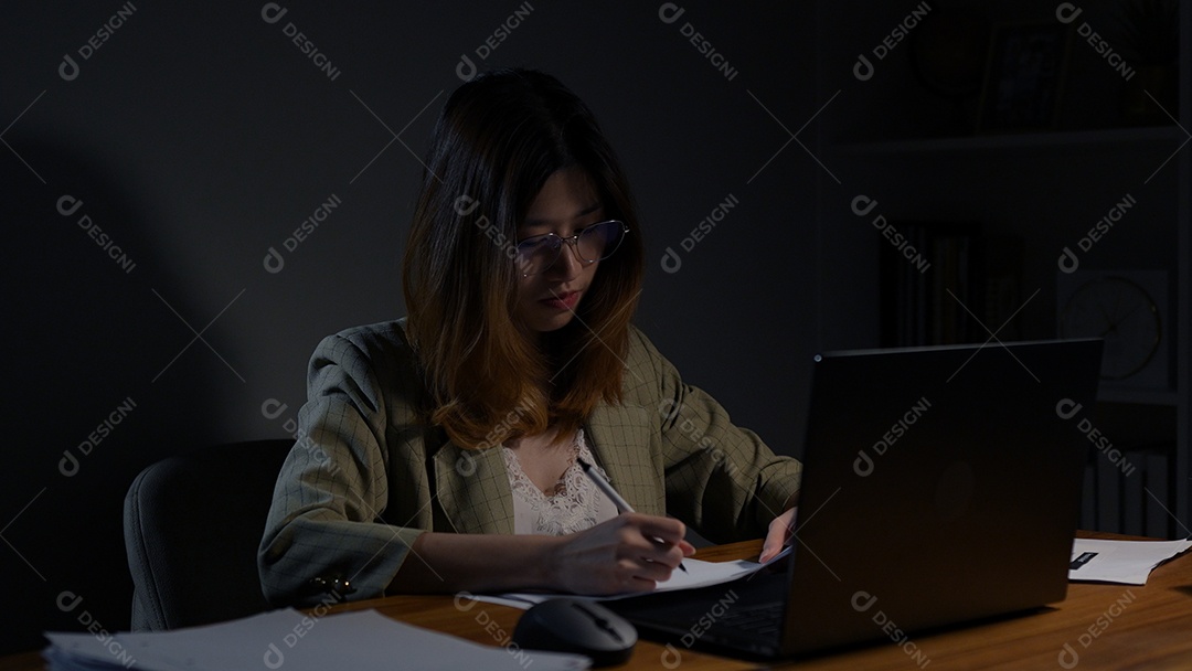 Empresária asiática ou freelancer trabalhando duro à noite olhando o computador