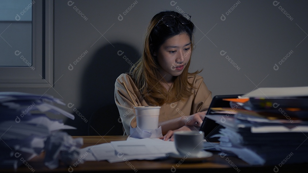 Empresária asiática ou freelancer trabalhando duro à noite olhando o computador