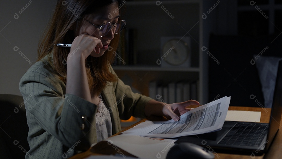 Empresária asiática ou freelancer trabalhando duro à noite olhando o computador