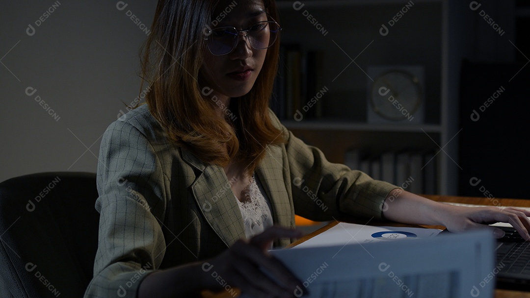 Empresária asiática ou freelancer trabalhando duro à noite olhando o computador