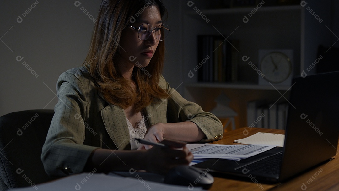 Empresária asiática ou freelancer trabalhando duro à noite olhando o computador