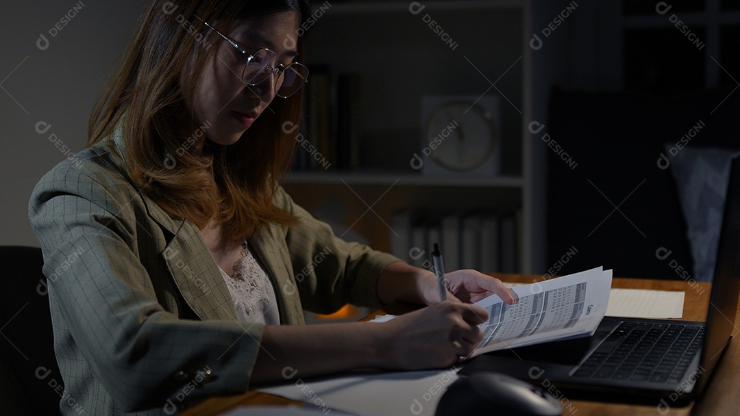 Empresária asiática ou freelancer trabalhando duro à noite olhando o computador