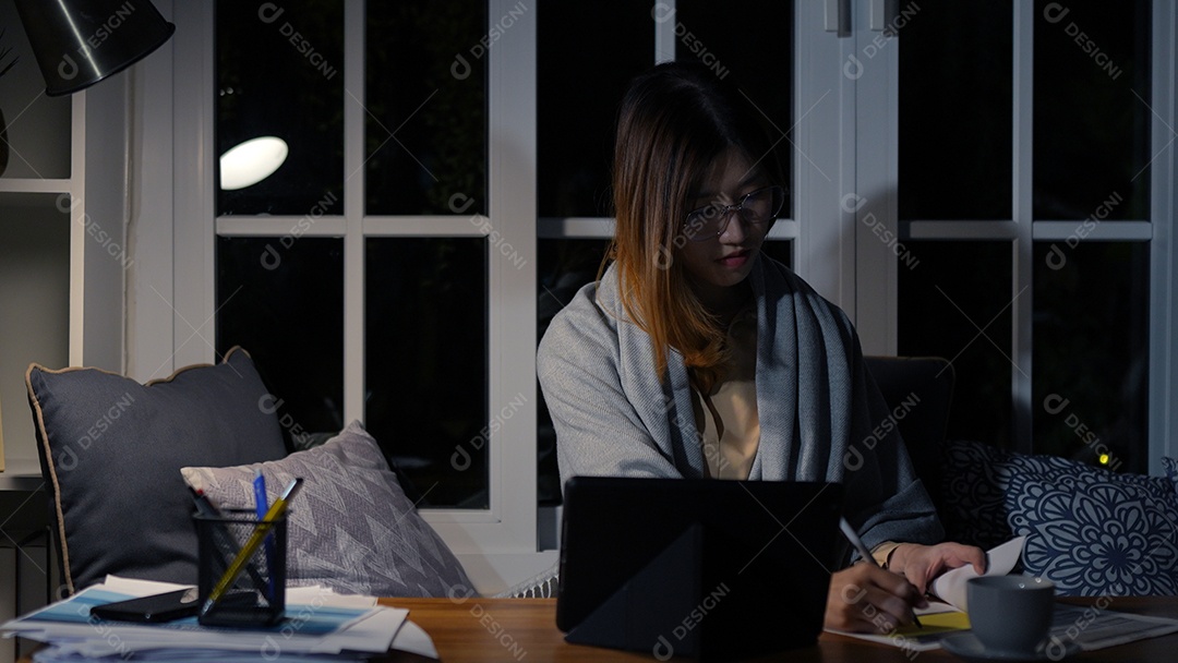 Empresária asiática ou freelancer trabalhando duro à noite olhando o computador