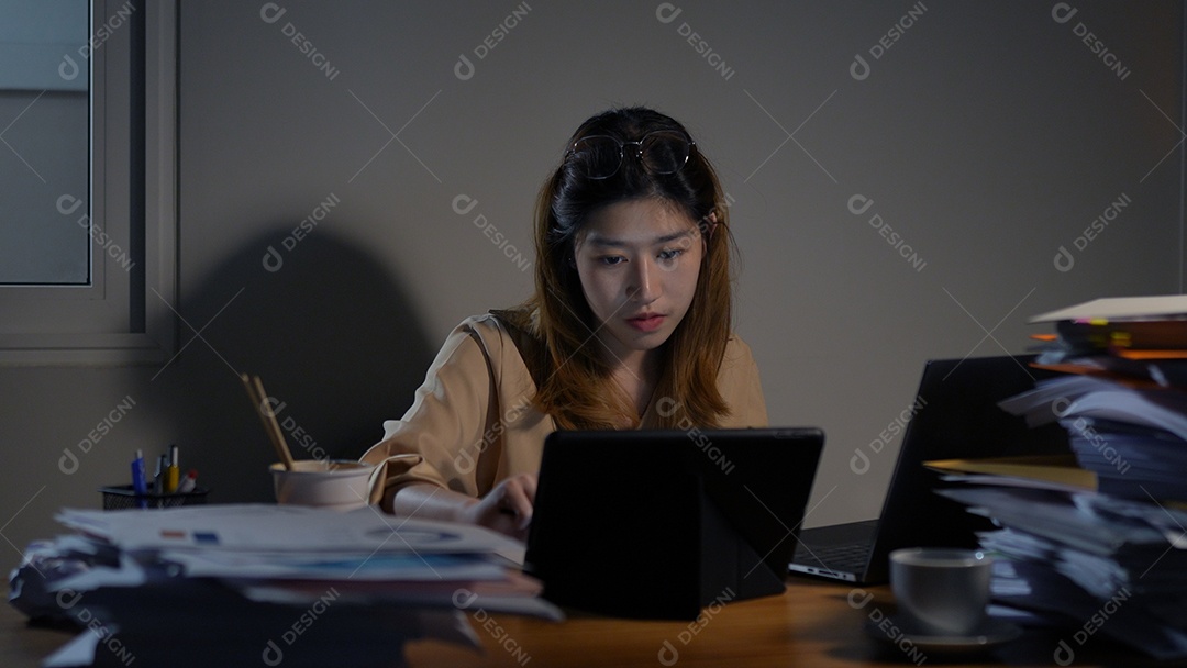 Empresária asiática ou freelancer trabalhando duro à noite olhando o computador