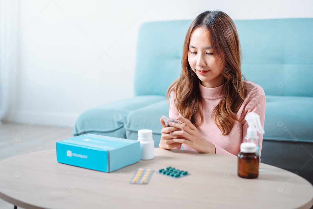 Paciente jovem asiática na mesa de alimentação com comprimidos