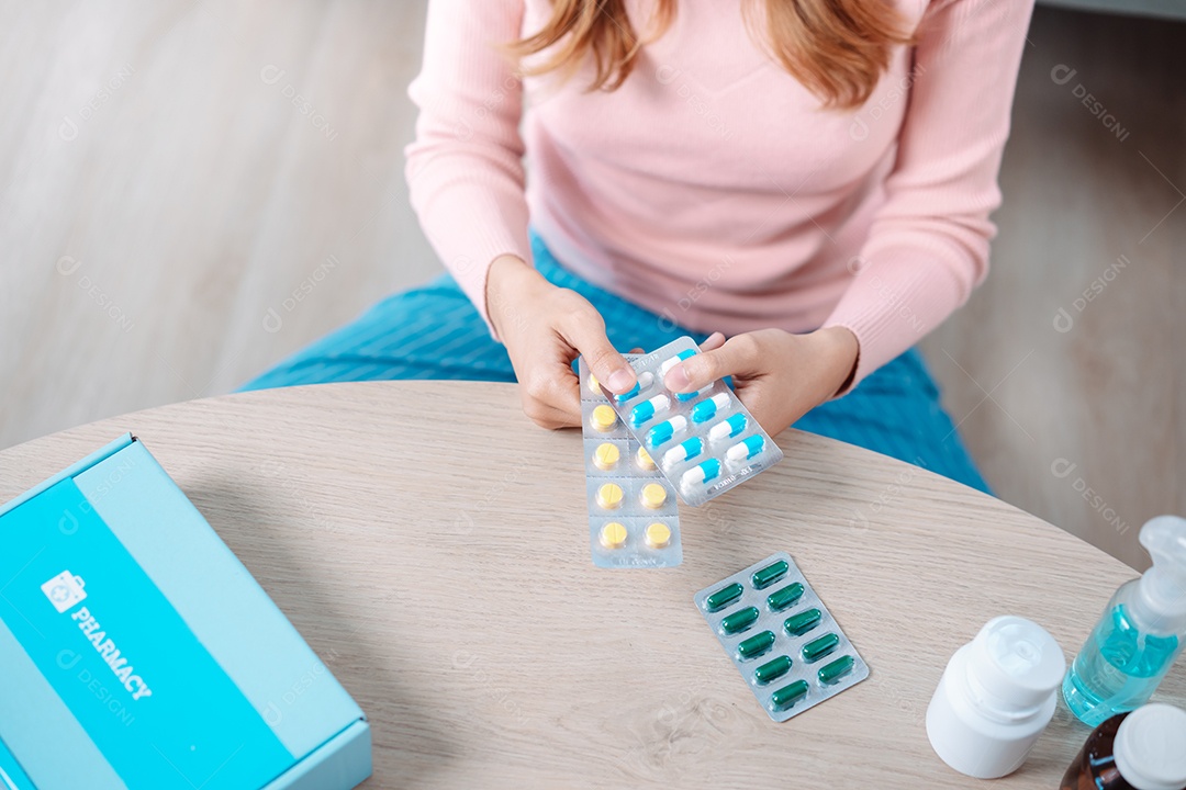Paciente jovem asiática na mesa de alimentação com comprimidos