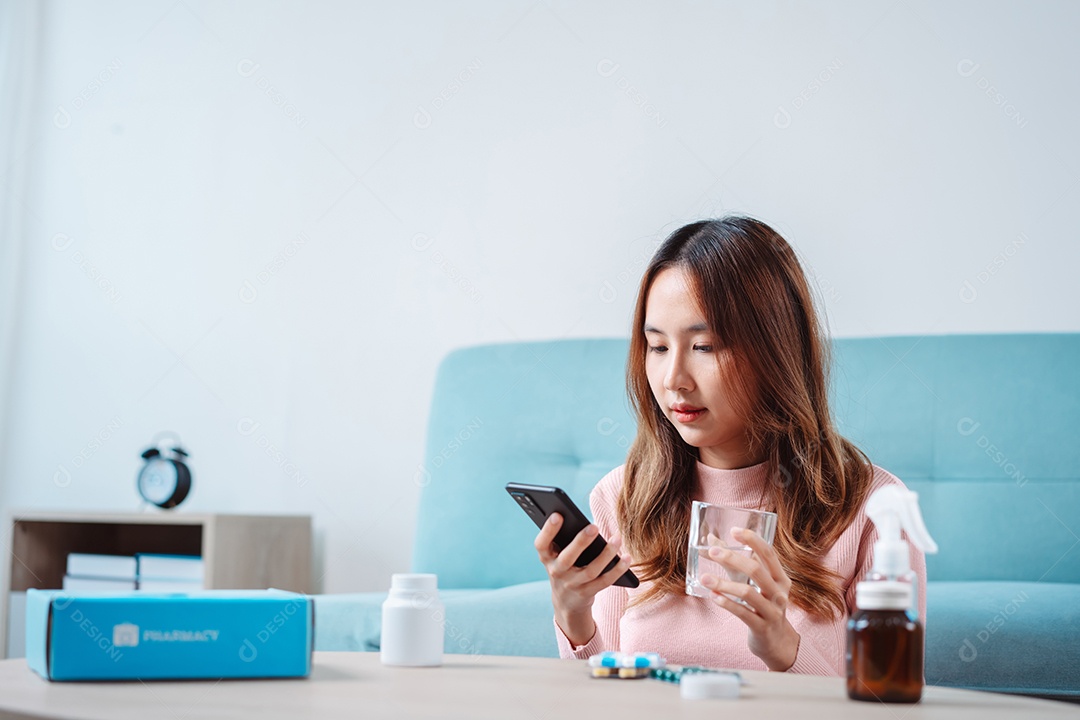 Paciente jovem asiática na mesa de alimentação com comprimidos