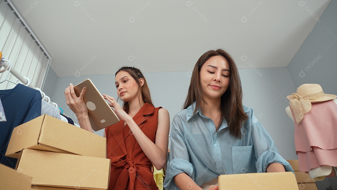 Bela blogueira asiática preparando o pedido para o cliente