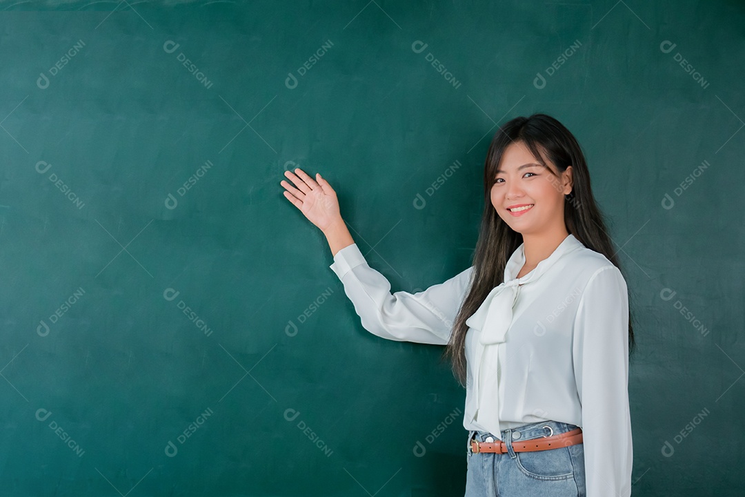 Retrato atraente de sorridente mulher professora asiática ensinando estudante em sala de aula