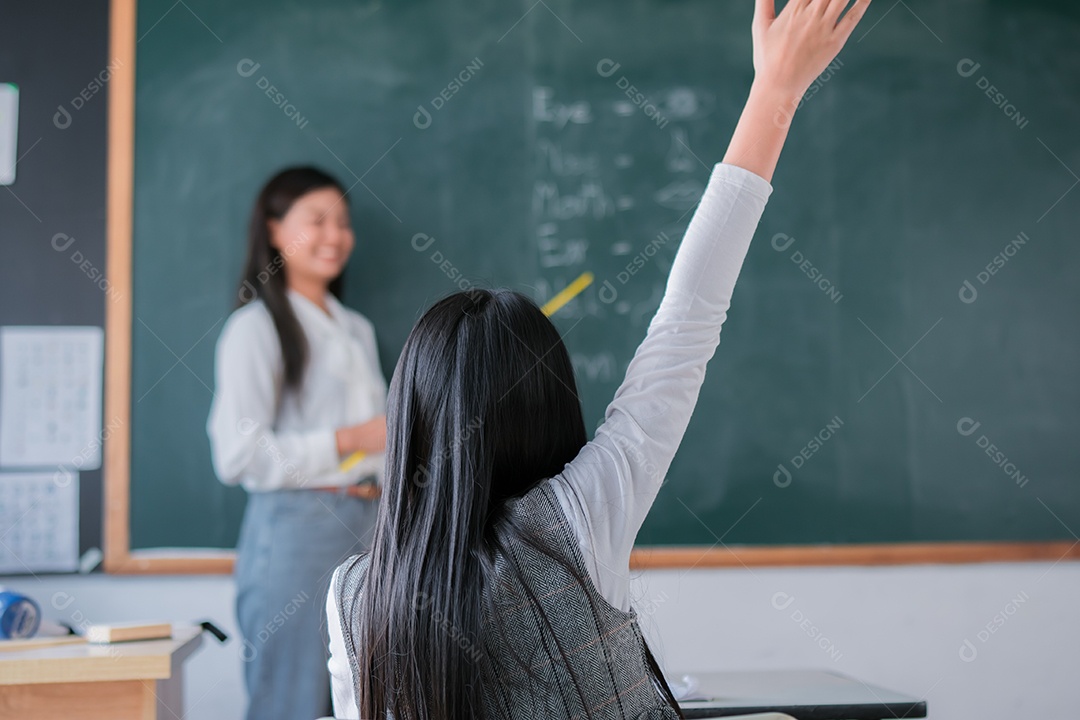 Mulher sorridente de professora asiática ensinando aluno em sala de aula