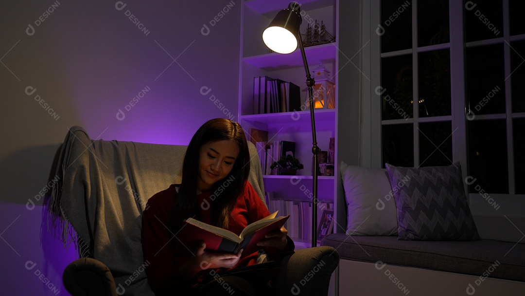 Jovem asiática sentada trabalhando horas extras fazendo negócios tardios no escritório à noite