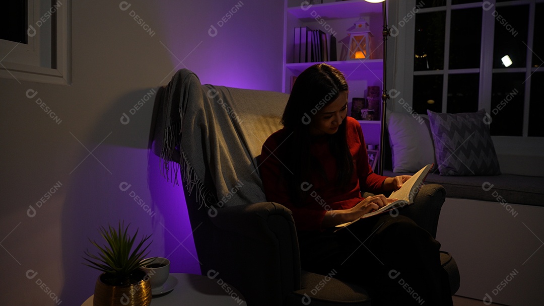 Jovem asiática sentada trabalhando horas extras fazendo negócios tardios no escritório à noite